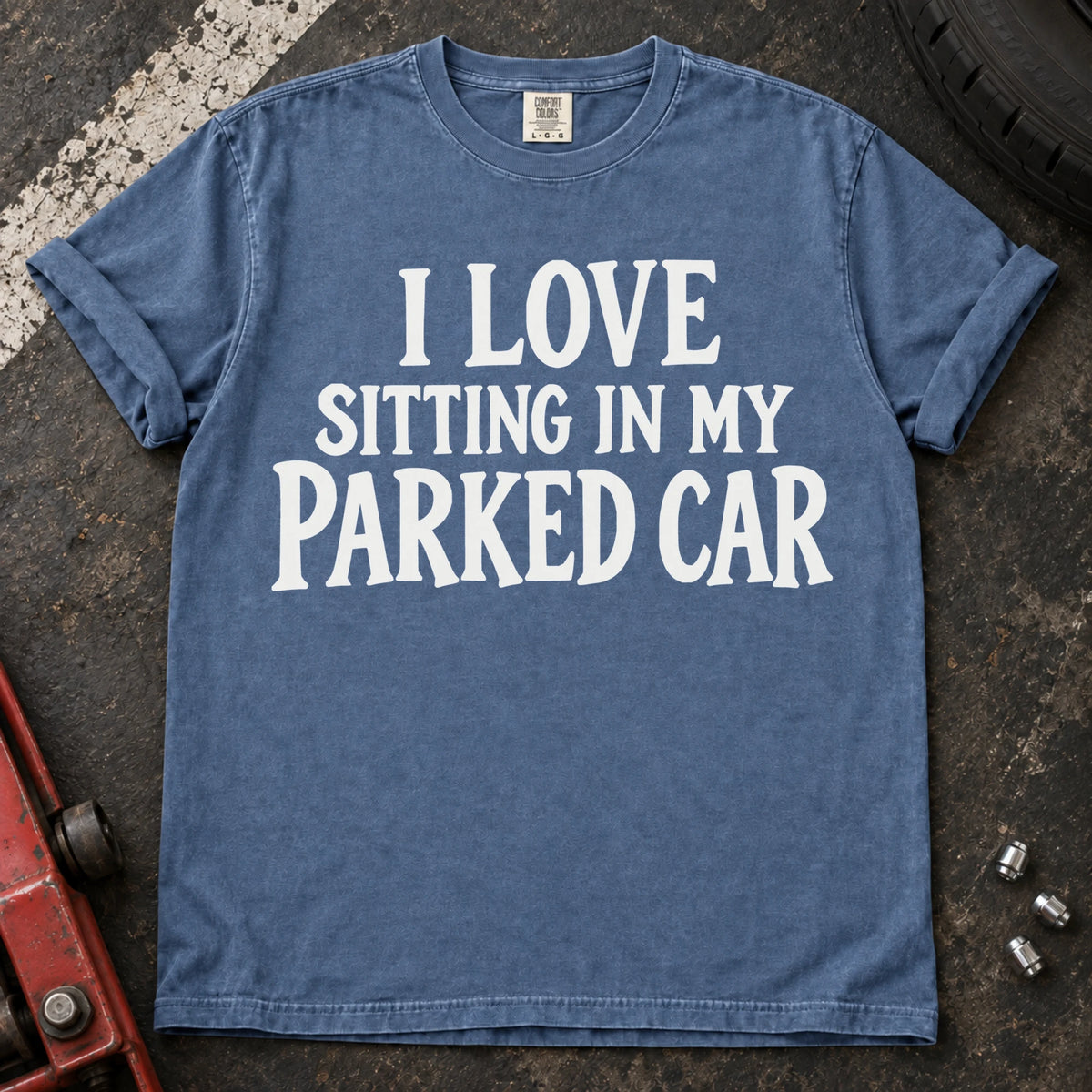 Blue Jean T-shirt with serif lettering reading 'I love sitting in my parked car'.