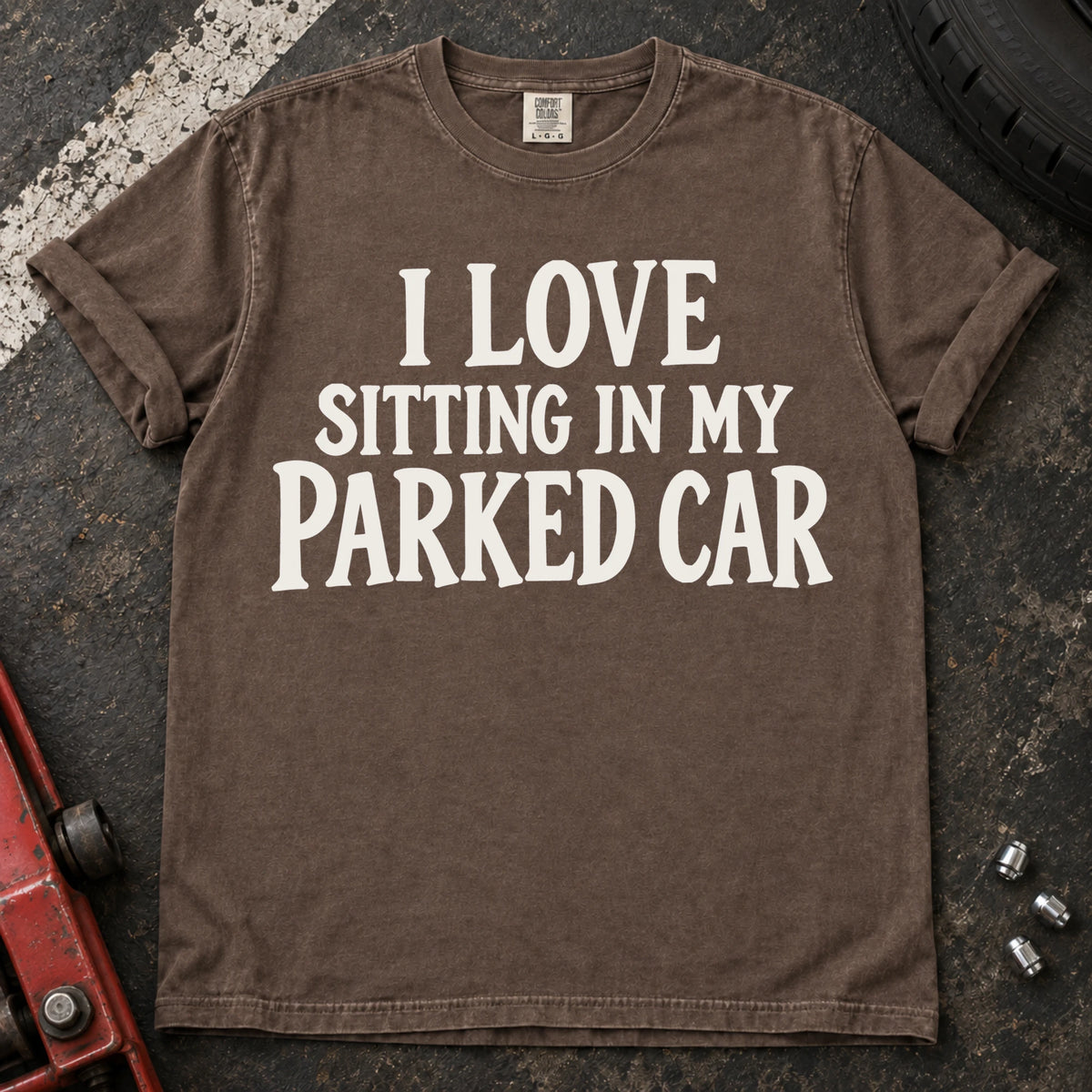 Espresso T-shirt with serif lettering reading 'I love sitting in my parked car'.