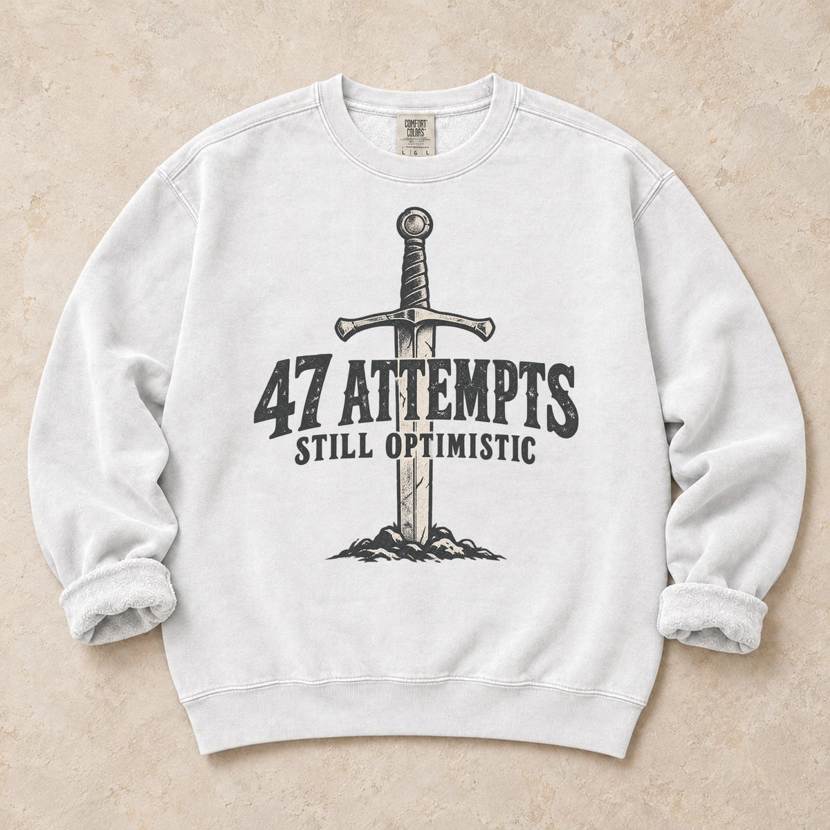 White gaming sweatshirt. A planted sword celebrates 47 attempts and still optimistic.