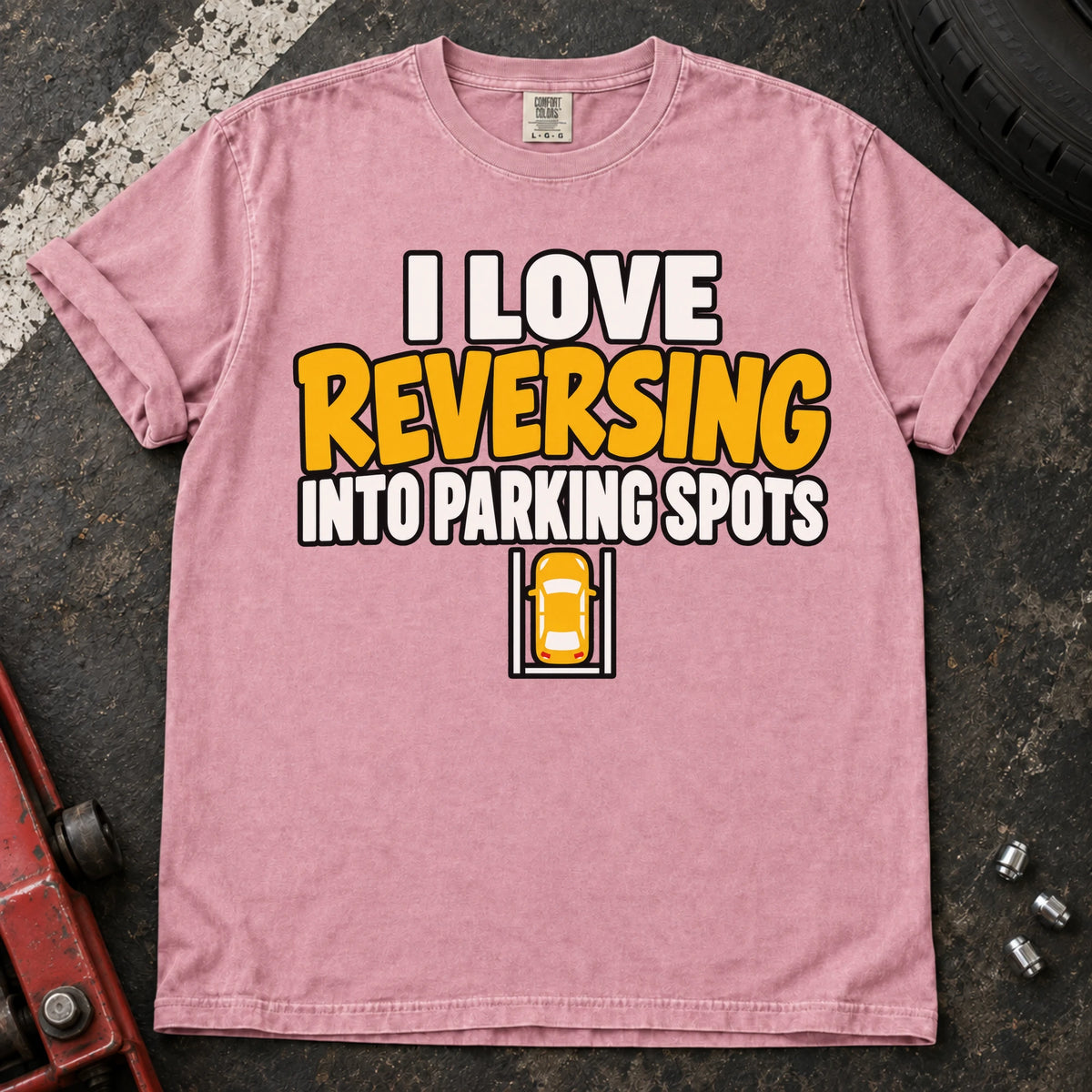 Blossom T-shirt reading 'I love reversing into parking spots' above a small overhead car in a parking bay.