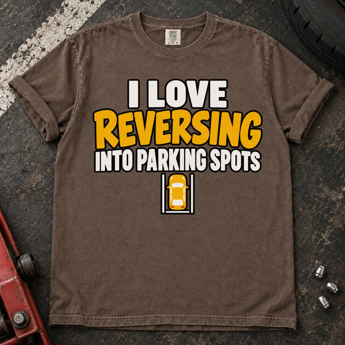 Espresso T-shirt reading 'I love reversing into parking spots' above a small overhead car in a parking bay.