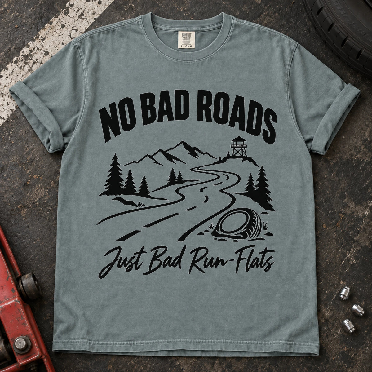 Bay car enthusiast T-shirt. A mountain road and failed tire explain no bad roads, just bad run-flats.