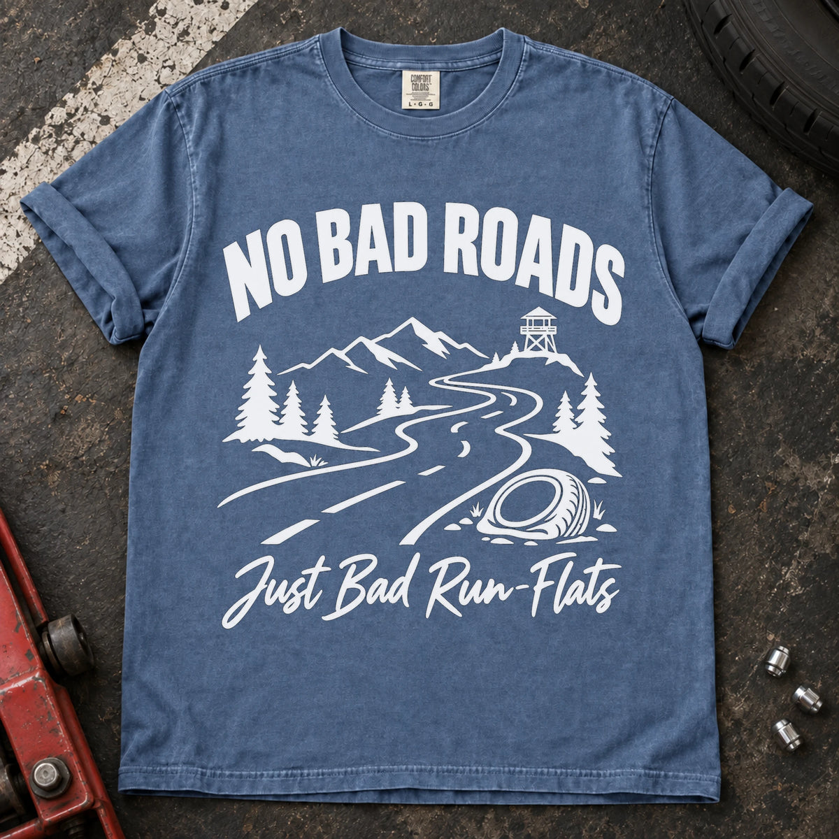 Blue Jean car enthusiast T-shirt. A mountain road and failed tire explain no bad roads, just bad run-flats.