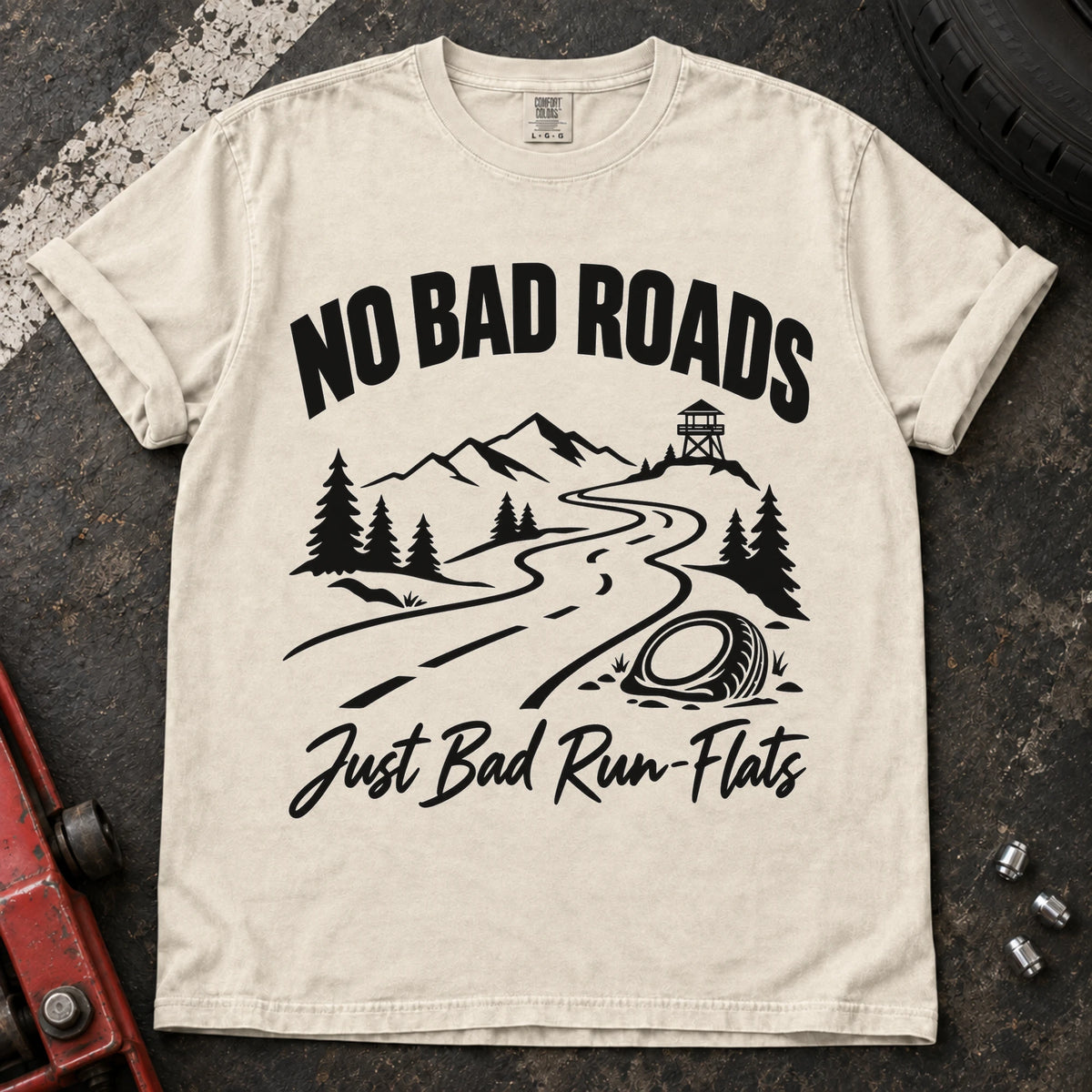 Ivory car enthusiast T-shirt. A mountain road and failed tire explain no bad roads, just bad run-flats.
