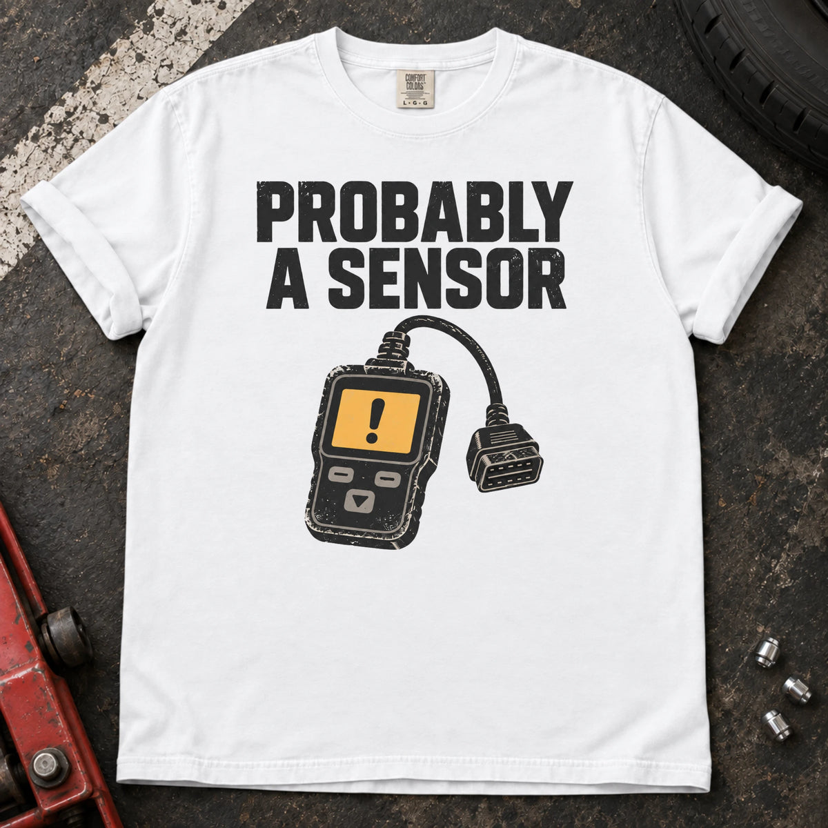 White car enthusiast T-shirt. A diagnostic scanner backs the hopeful diagnosis, probably a sensor.