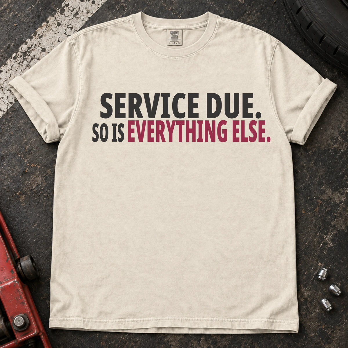 Ivory T-shirt with bold black lettering reading 'Service due. So is everything else'.