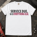 White T-shirt with bold black lettering reading 'Service due. So is everything else'.