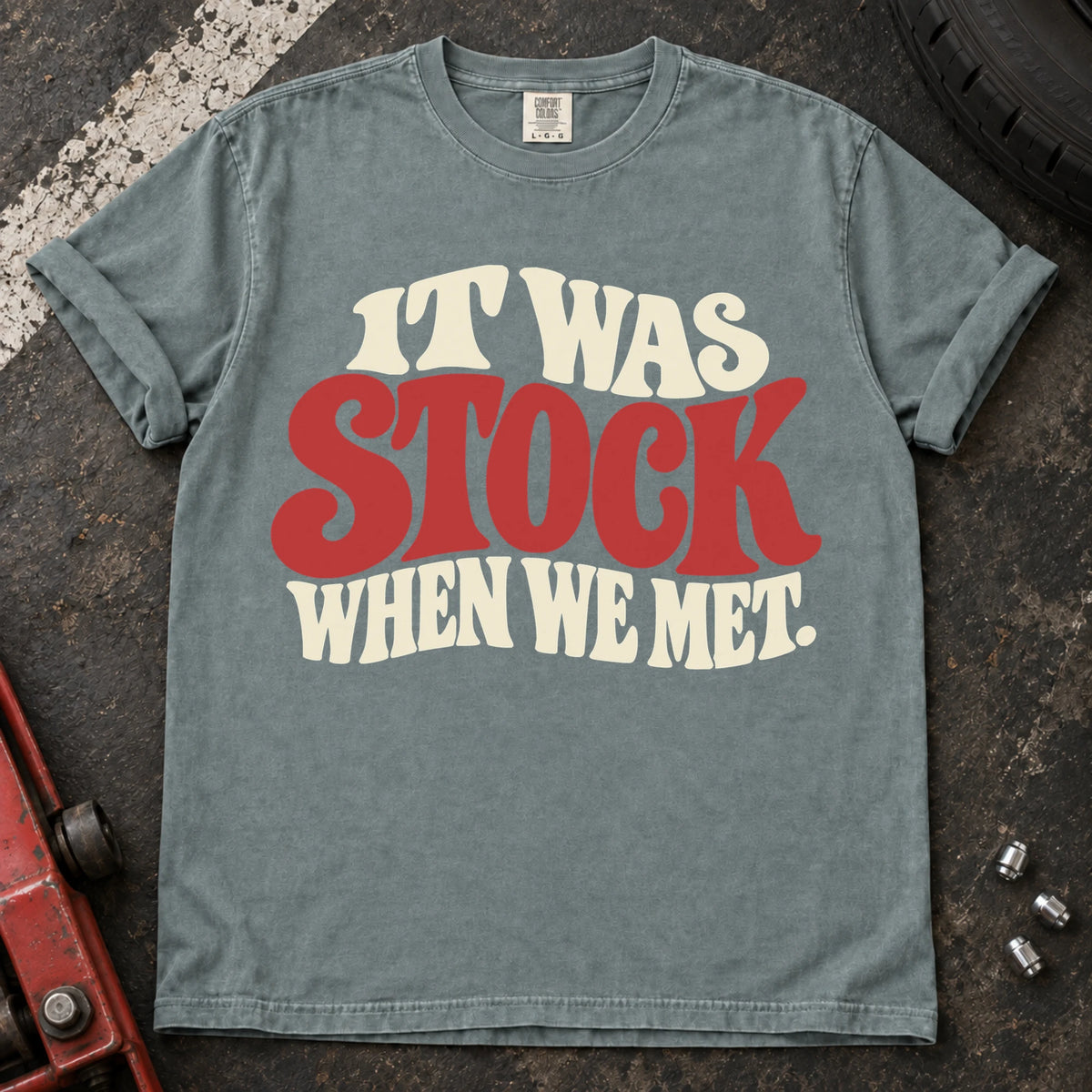 Bay T-shirt with cream and red vintage lettering reading 'It was stock when we met'.