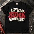 Black T-shirt with cream and red vintage lettering reading 'It was stock when we met'.