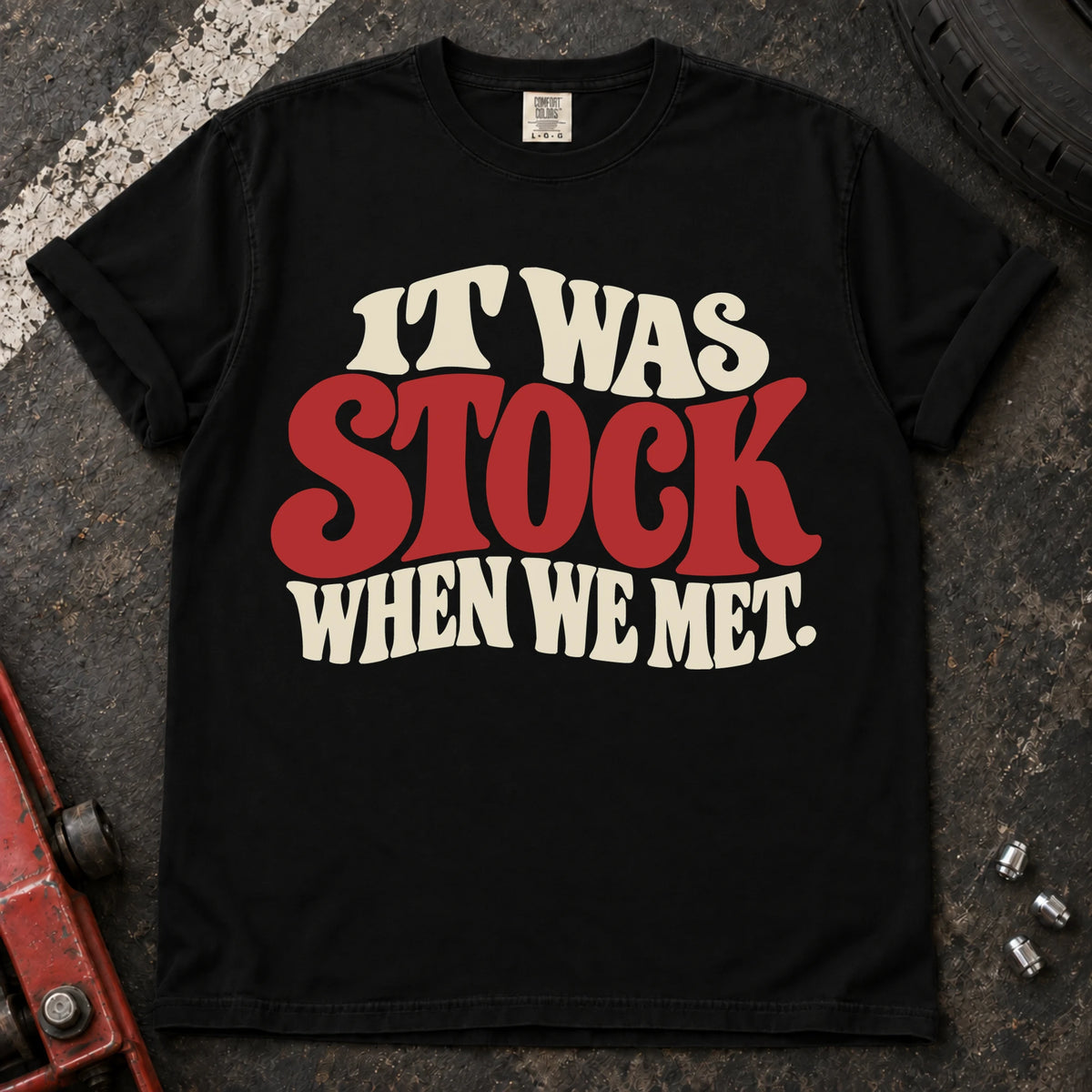 Black T-shirt with cream and red vintage lettering reading 'It was stock when we met'.