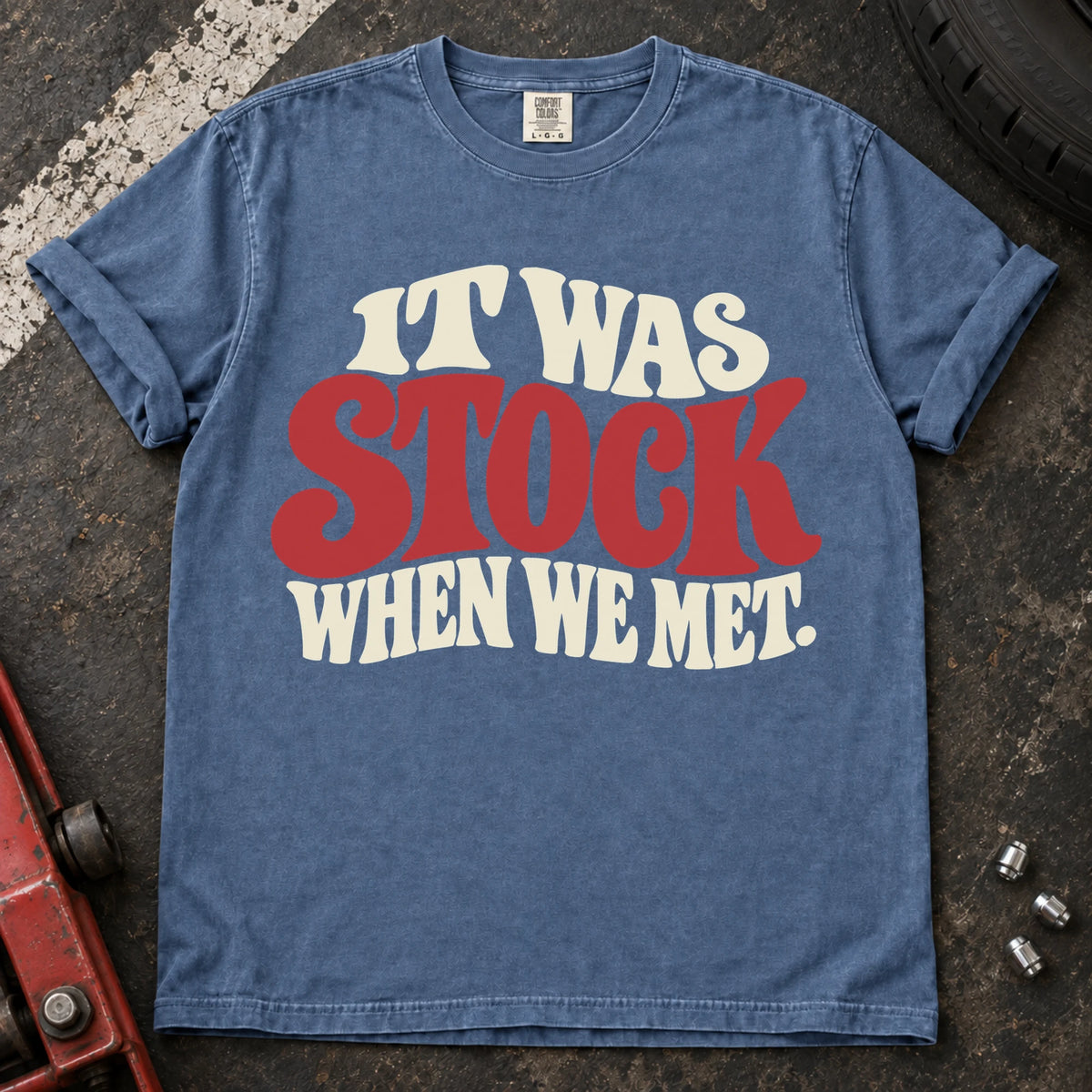 Blue Jean T-shirt with cream and red vintage lettering reading 'It was stock when we met'.