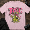 Light Pink gaming T-shirt. A mischievous green potion spills beneath Toxic lettering.