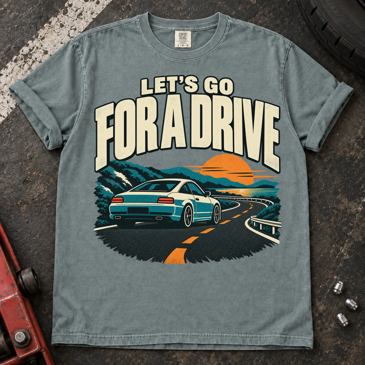 Bay car enthusiast T-shirt. A car cruises a sunset mountain road under let's go for a drive.