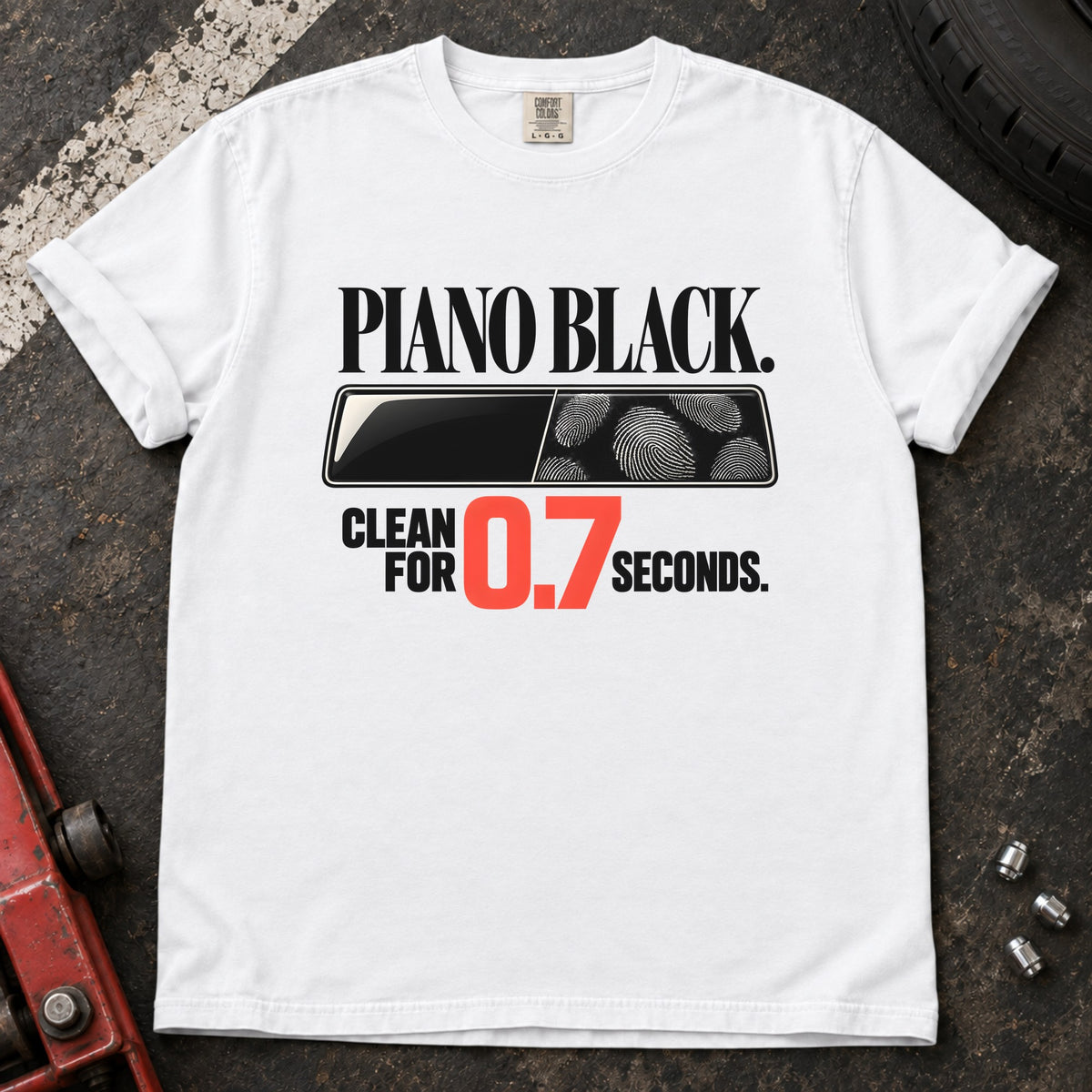 White T-shirt showing fingerprints on a trim panel with 'Piano black. Clean for 0.7 seconds'.
